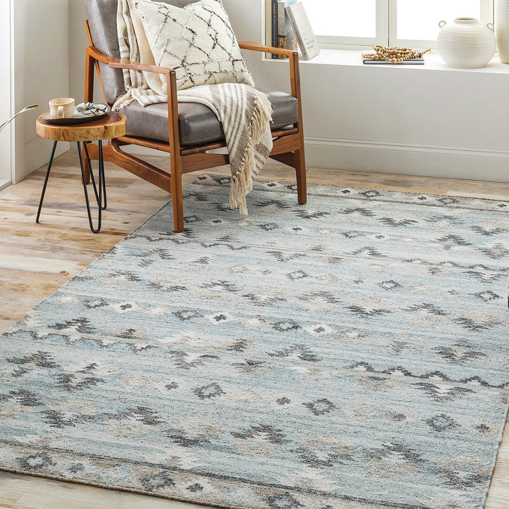 Upholstered recliner on area rug with accent table