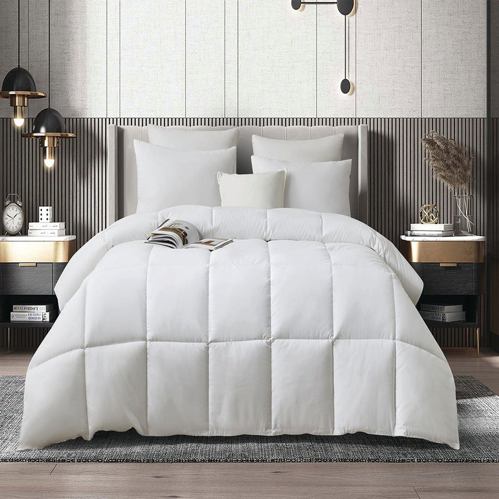 White quilt with pillows on wood bed