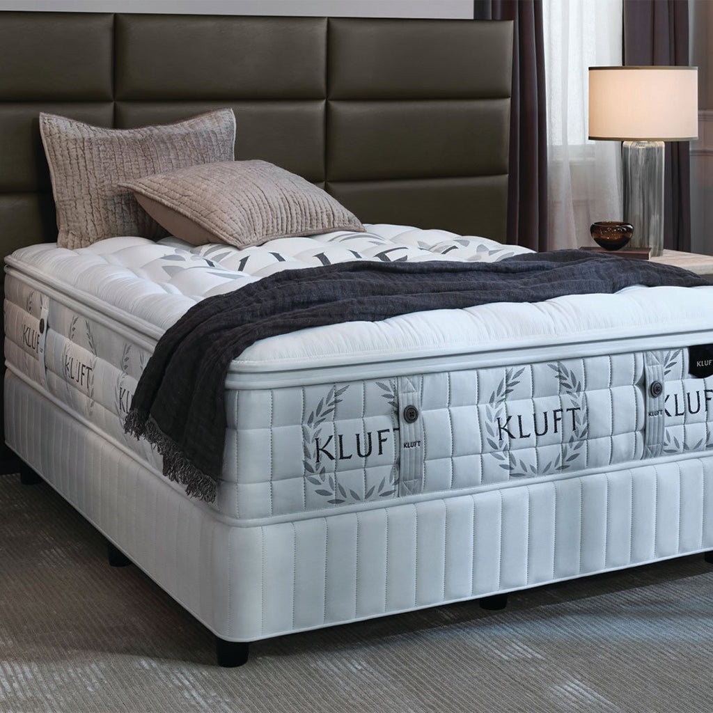 Mattress on metal bed with pillows